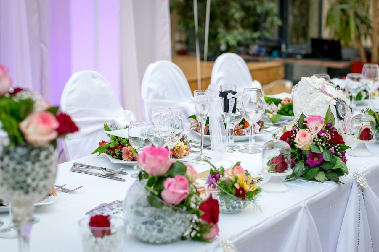 Beautifully decorated wedding table setting with floral arrangements and wine glasses, creating an elegant atmosphere.